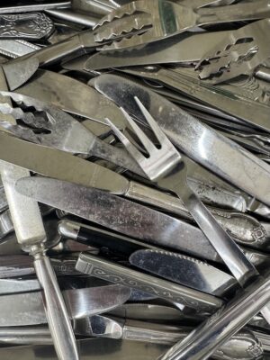 Assorted Worn Stainless Steel Knives And Forks In A Drawer