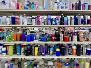 Cups And Tumblers Lined On A Shelf At A Thrift Store