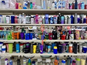 Cups And Tumblers Lined One a Shelf At A Thrift Store