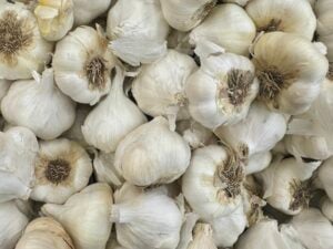 Several Garlic Gloves For Sale At A Grocery Store
