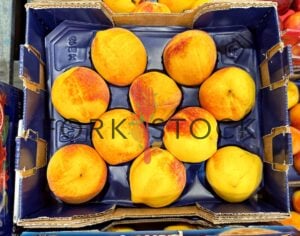 Yellow Peaches On Display In A Box At A Warehouse Store
